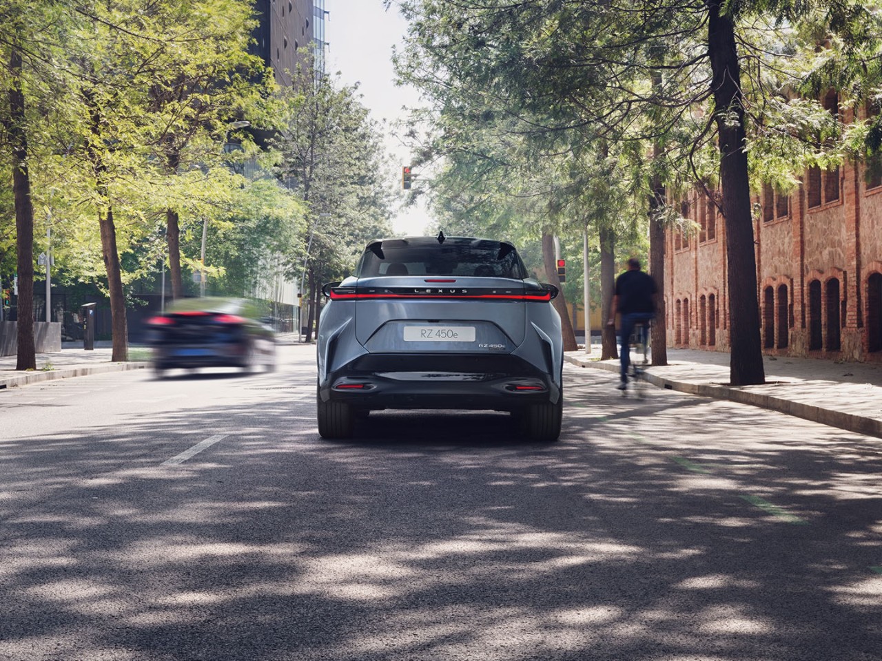 Rear view of the Lexus RZ driving on a road